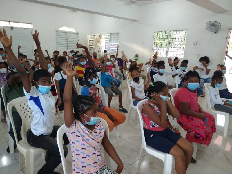 Crianças levantando a mão numa classe de sábado